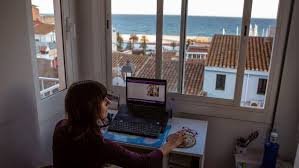 working in Spain as a foreigner 2026 — remote worker at desk with Spanish sea view through window