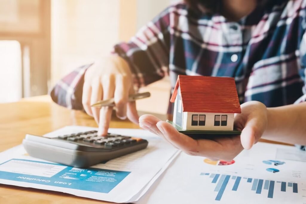 Cancel a mortgage in Spain — person calculating mortgage cancellation fees with house model and loan documents
