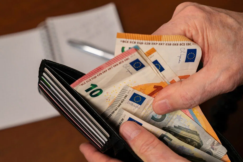 Cash payment Spain rules 2026 — hands holding euro banknotes over an open wallet