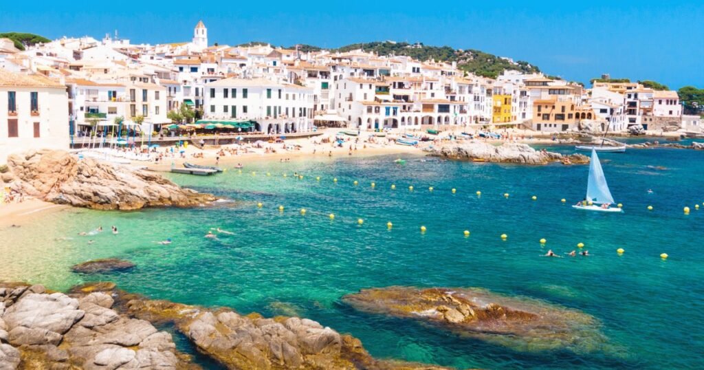 Foreign mortgages Spain 2026 statistics - coastal Spanish town with beach, harbor and whitewashed buildings